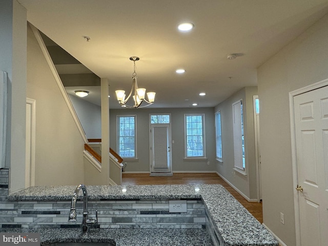 foyer featuring sink, hardwood / wood-style floors, and an inviting chandelier