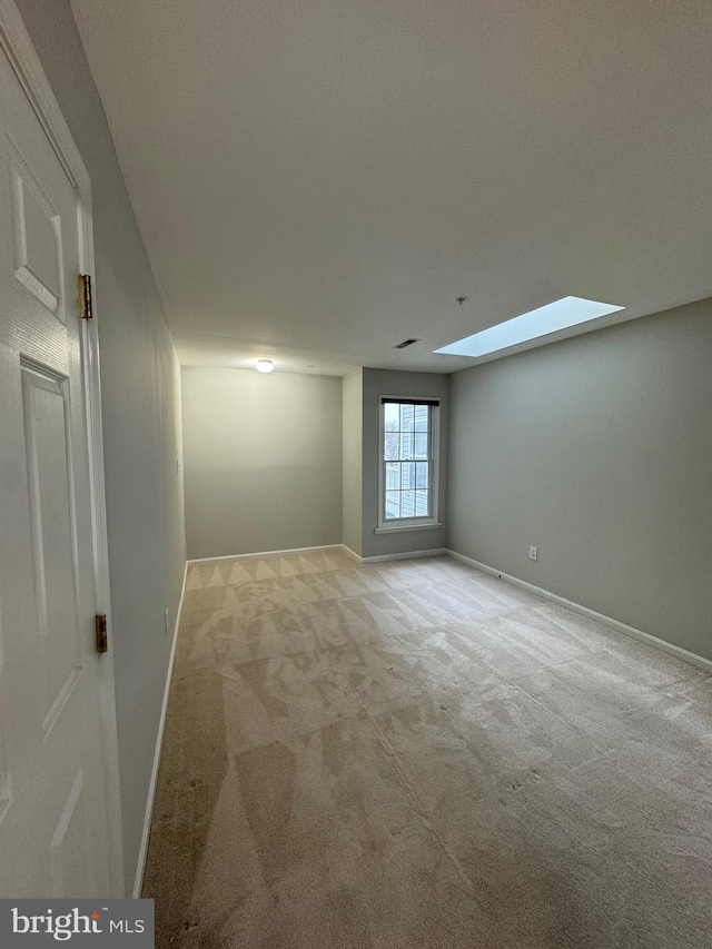 carpeted spare room with a skylight