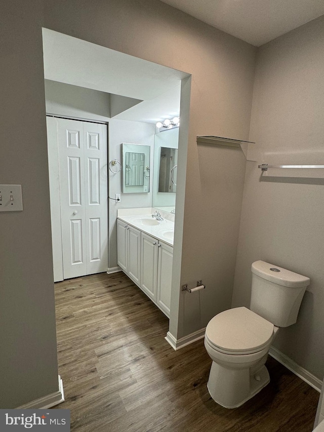 bathroom featuring hardwood / wood-style flooring, vanity, and toilet