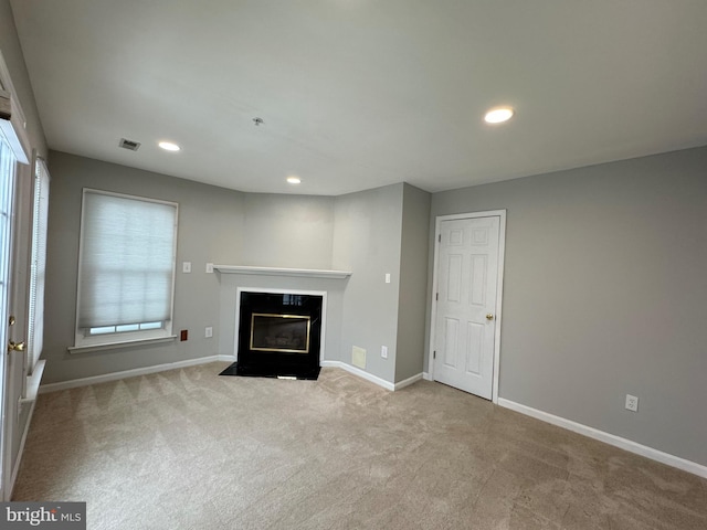 unfurnished living room featuring light colored carpet