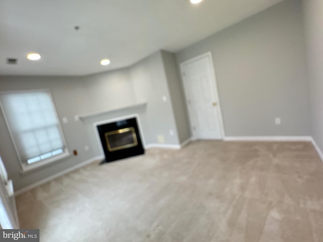 unfurnished living room with light carpet and a fireplace