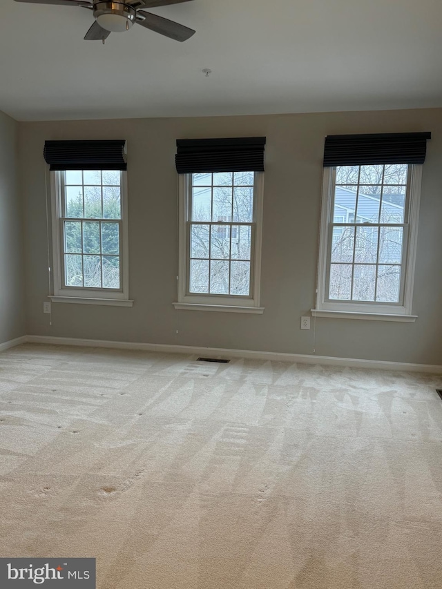 unfurnished room with ceiling fan and light carpet