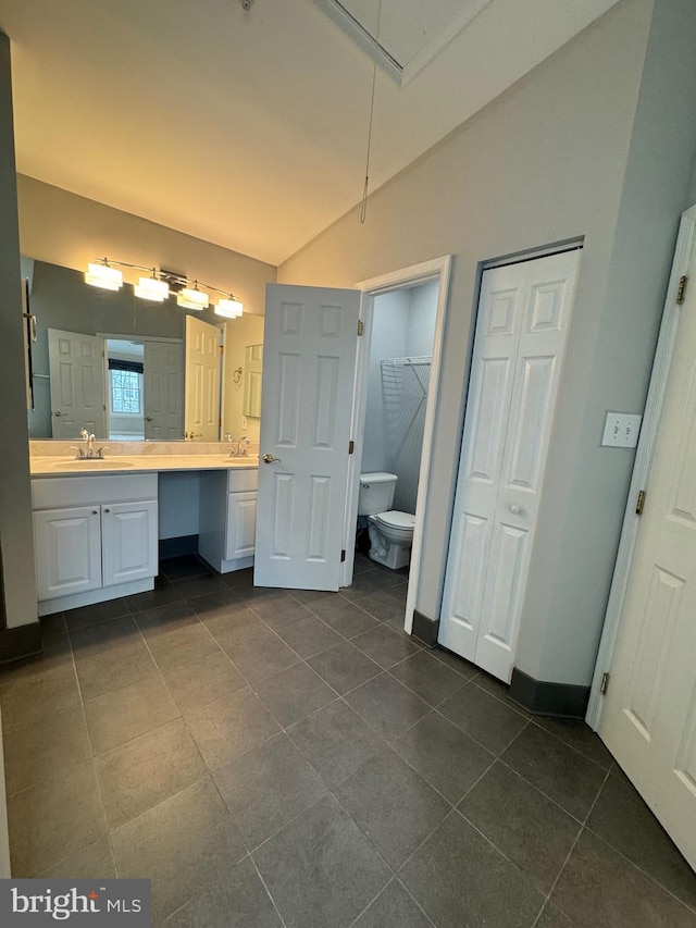 bathroom featuring vanity, tile patterned flooring, vaulted ceiling, and toilet