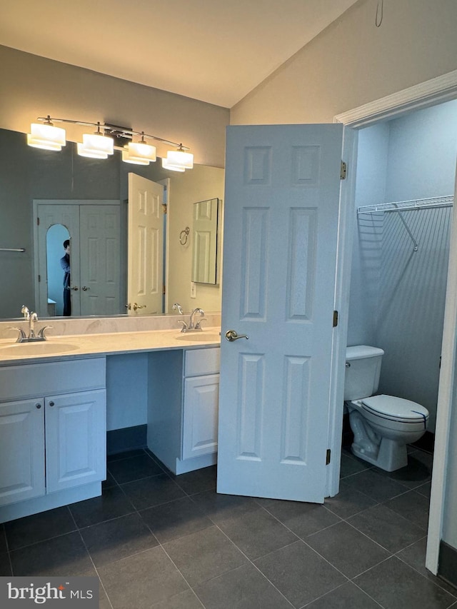 bathroom with lofted ceiling, vanity, toilet, and tile patterned flooring