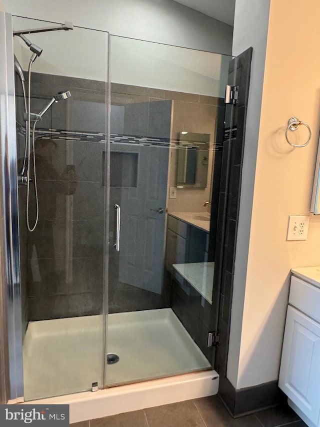 bathroom featuring vanity, a shower with shower door, and tile patterned floors