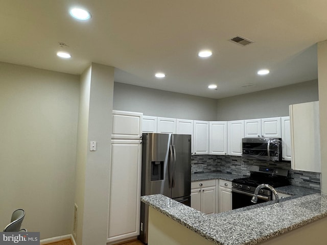 kitchen featuring backsplash, white cabinets, light stone counters, kitchen peninsula, and stainless steel appliances