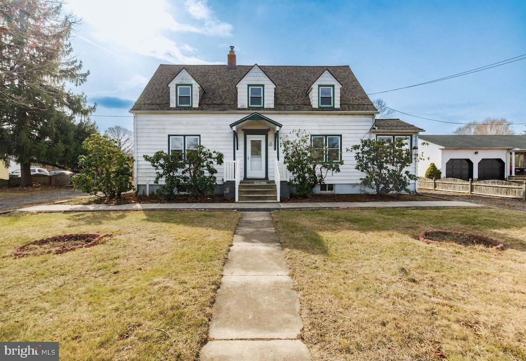 cape cod home featuring a front lawn