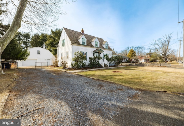 cape cod house with a garage, an outbuilding, and a front lawn