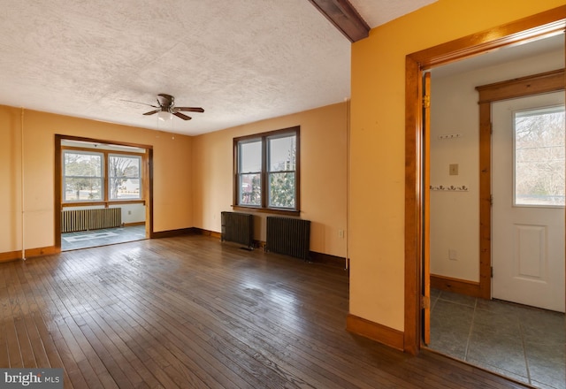 unfurnished living room featuring dark hardwood / wood-style flooring and radiator