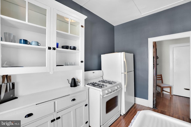 kitchen featuring dark hardwood / wood-style flooring, gas range gas stove, and white cabinets