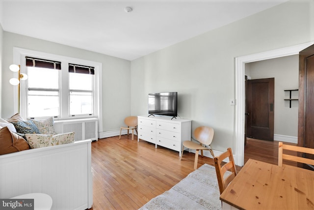 living room with radiator heating unit and light wood-type flooring