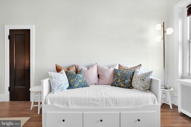 bedroom featuring hardwood / wood-style flooring and radiator