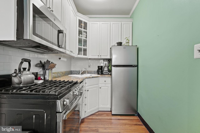 kitchen featuring white cabinetry, appliances with stainless steel finishes, sink, and decorative backsplash