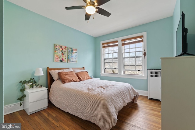 bedroom featuring radiator, wood-type flooring, and ceiling fan