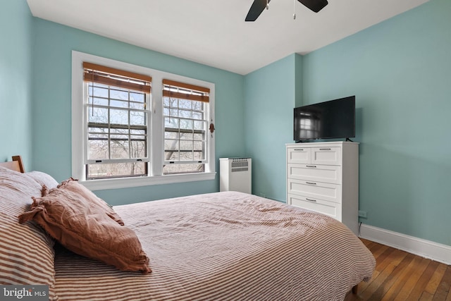 bedroom featuring ceiling fan, radiator, and hardwood / wood-style floors