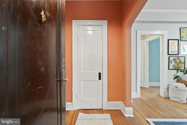 hall with crown molding and light wood-type flooring