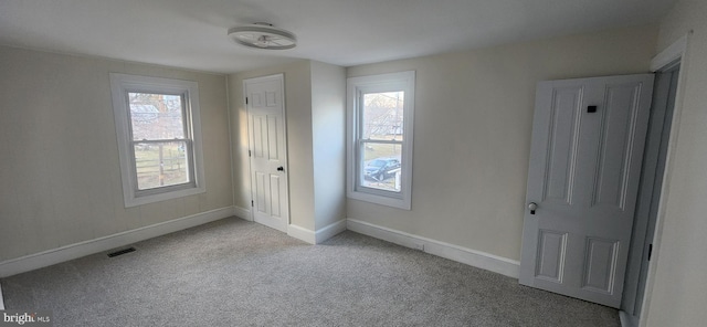 unfurnished bedroom featuring multiple windows and light carpet