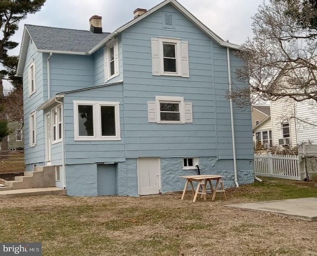 rear view of property featuring a yard