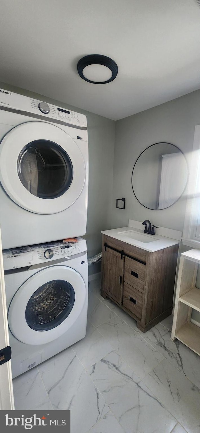 washroom featuring cabinets, stacked washer / drying machine, and sink