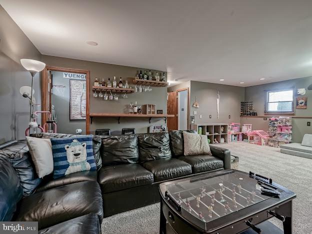 carpeted living room featuring indoor bar