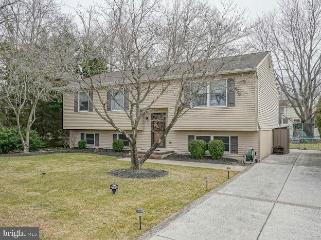 split foyer home featuring a trampoline and a front yard