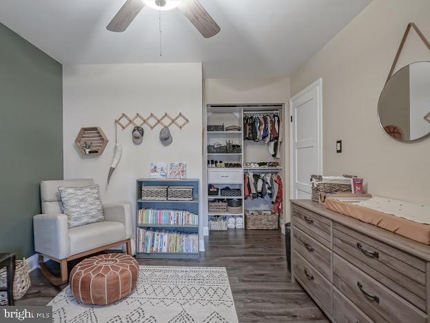 bedroom with dark wood-type flooring, a closet, and ceiling fan