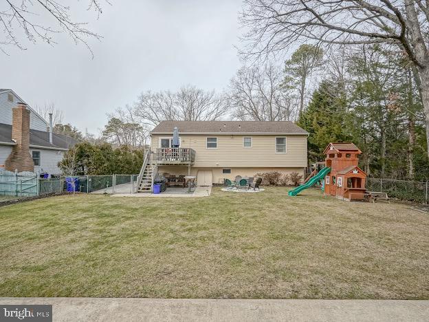 back of property with a playground, a lawn, and a patio area