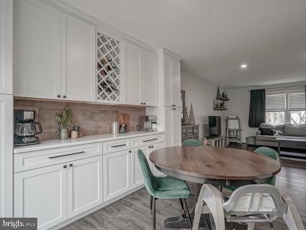 dining area featuring bar and light wood-type flooring