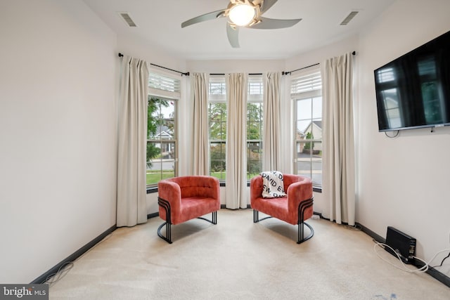 living area with light colored carpet and ceiling fan