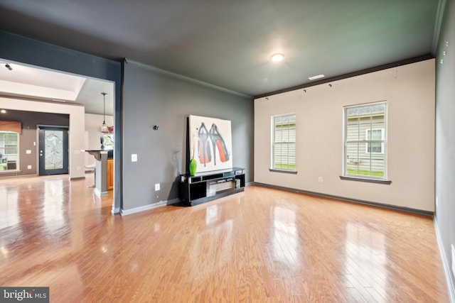 unfurnished living room with crown molding and light wood-type flooring