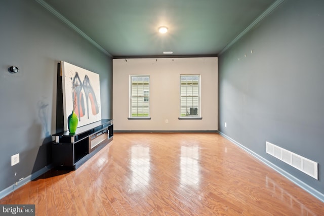 unfurnished living room featuring crown molding and light hardwood / wood-style floors