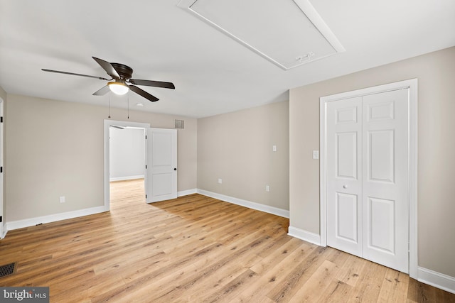 unfurnished bedroom with ceiling fan, light wood-type flooring, and a closet