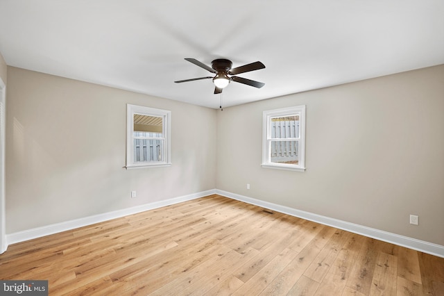 unfurnished room featuring ceiling fan, a wealth of natural light, and light hardwood / wood-style floors