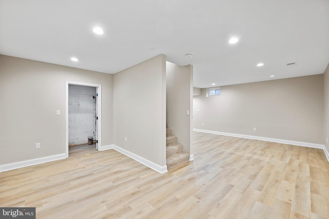 basement with light hardwood / wood-style flooring