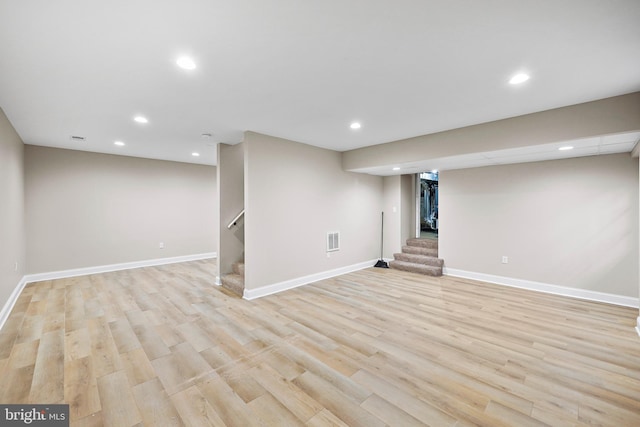 basement with light hardwood / wood-style flooring