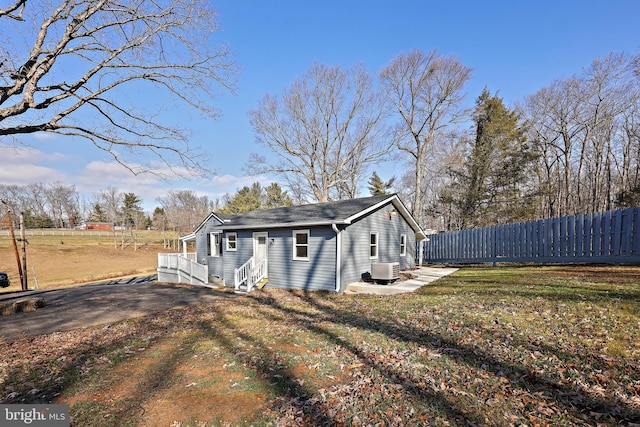 view of property exterior with cooling unit and a yard