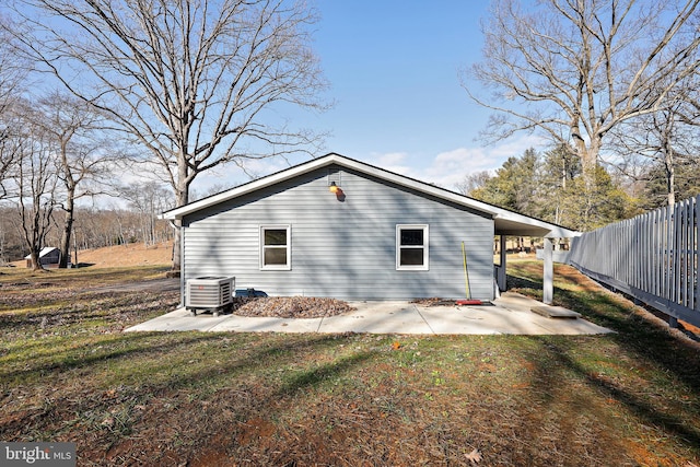 view of side of home with a lawn, a patio area, and central air condition unit