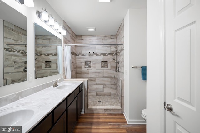 bathroom with wood-type flooring, toilet, vanity, and a shower with curtain