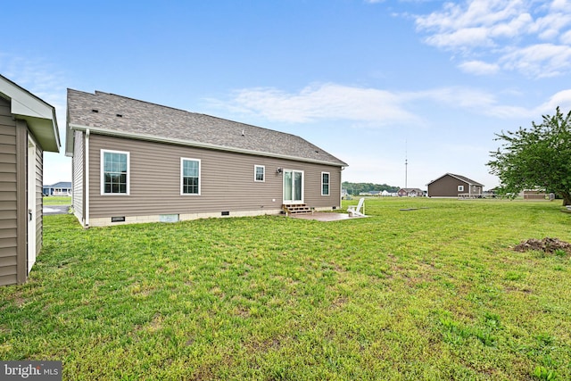 back of property with a yard and a patio area