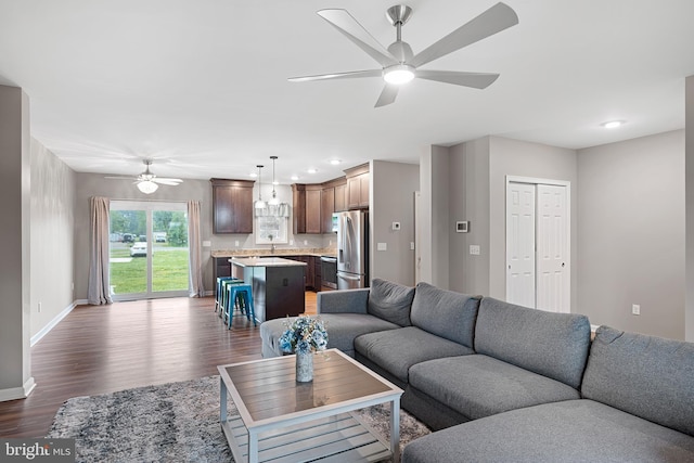 living room featuring ceiling fan and dark hardwood / wood-style flooring