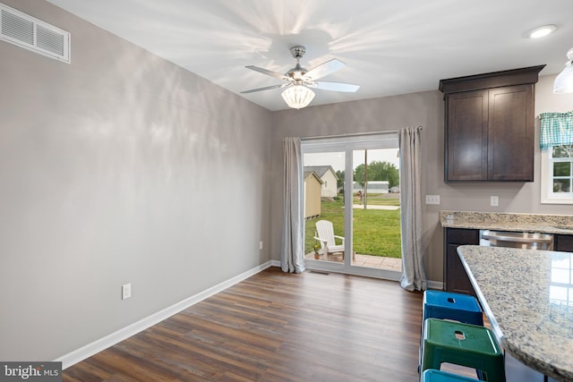 unfurnished dining area with ceiling fan and dark hardwood / wood-style flooring