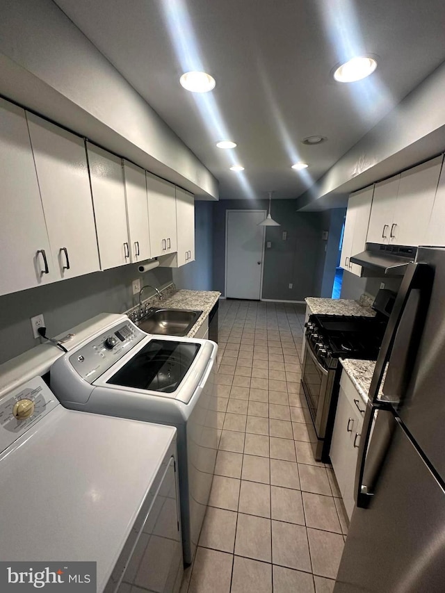 laundry room featuring washer and dryer, light tile patterned flooring, and sink