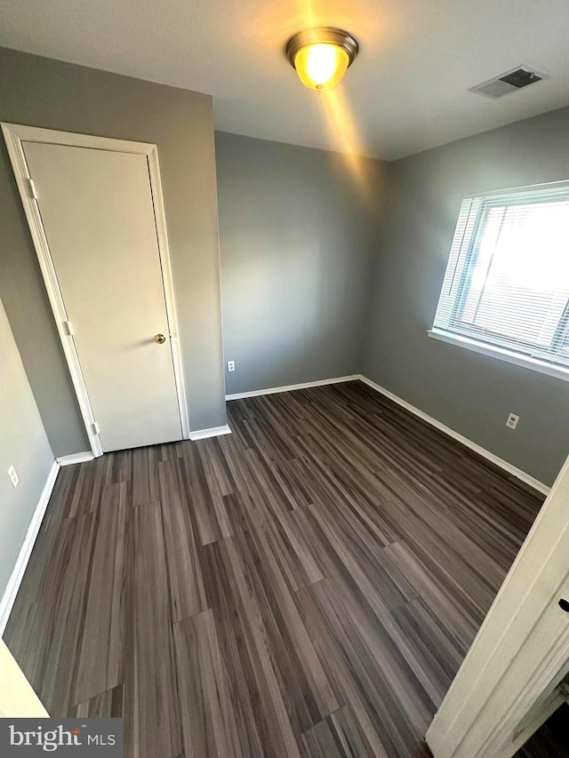 unfurnished bedroom featuring dark wood-type flooring