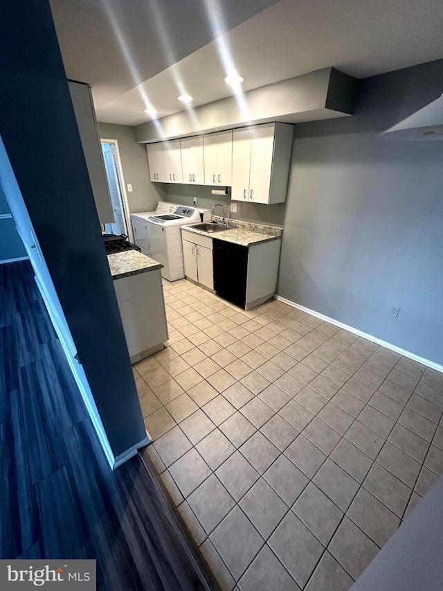 kitchen featuring light tile patterned flooring, washer and dryer, sink, and white cabinets