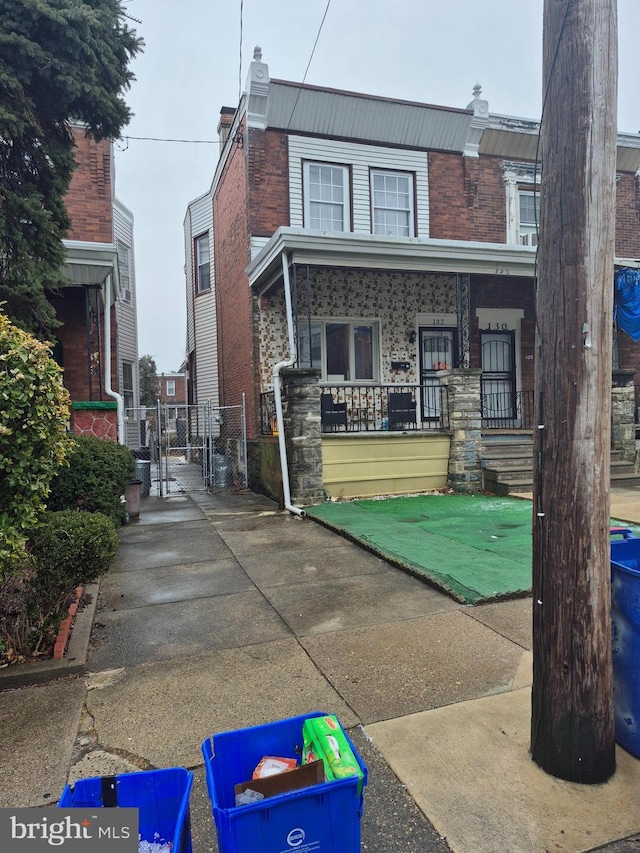 rear view of property featuring covered porch