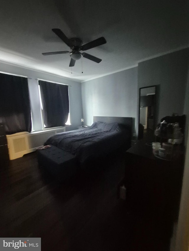 bedroom featuring hardwood / wood-style floors, ornamental molding, and ceiling fan