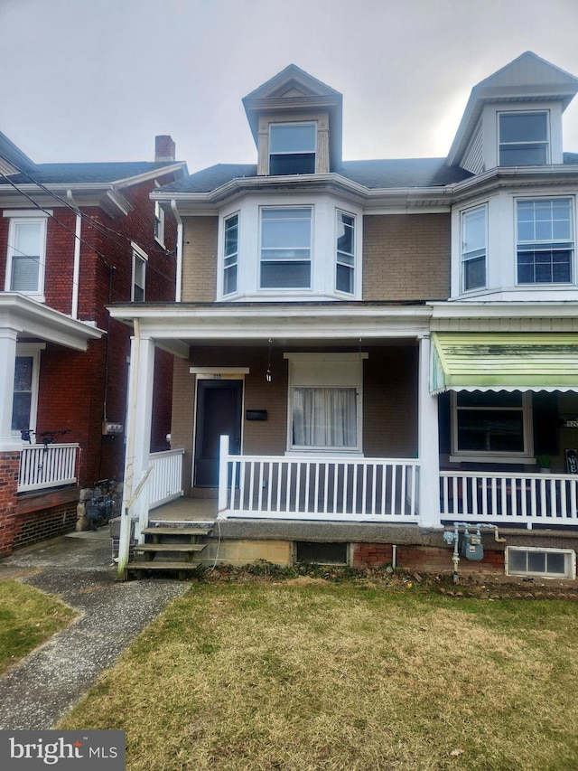 view of front of house featuring covered porch and a front lawn