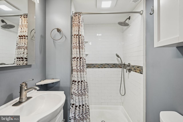 bathroom with a shower with curtain, toilet, and sink