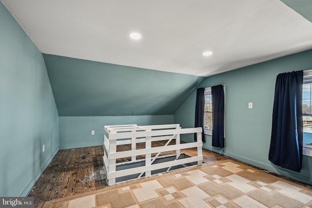 additional living space with lofted ceiling and hardwood / wood-style floors