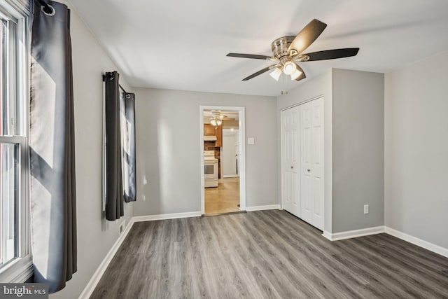 unfurnished bedroom with wood-type flooring, a closet, and ceiling fan